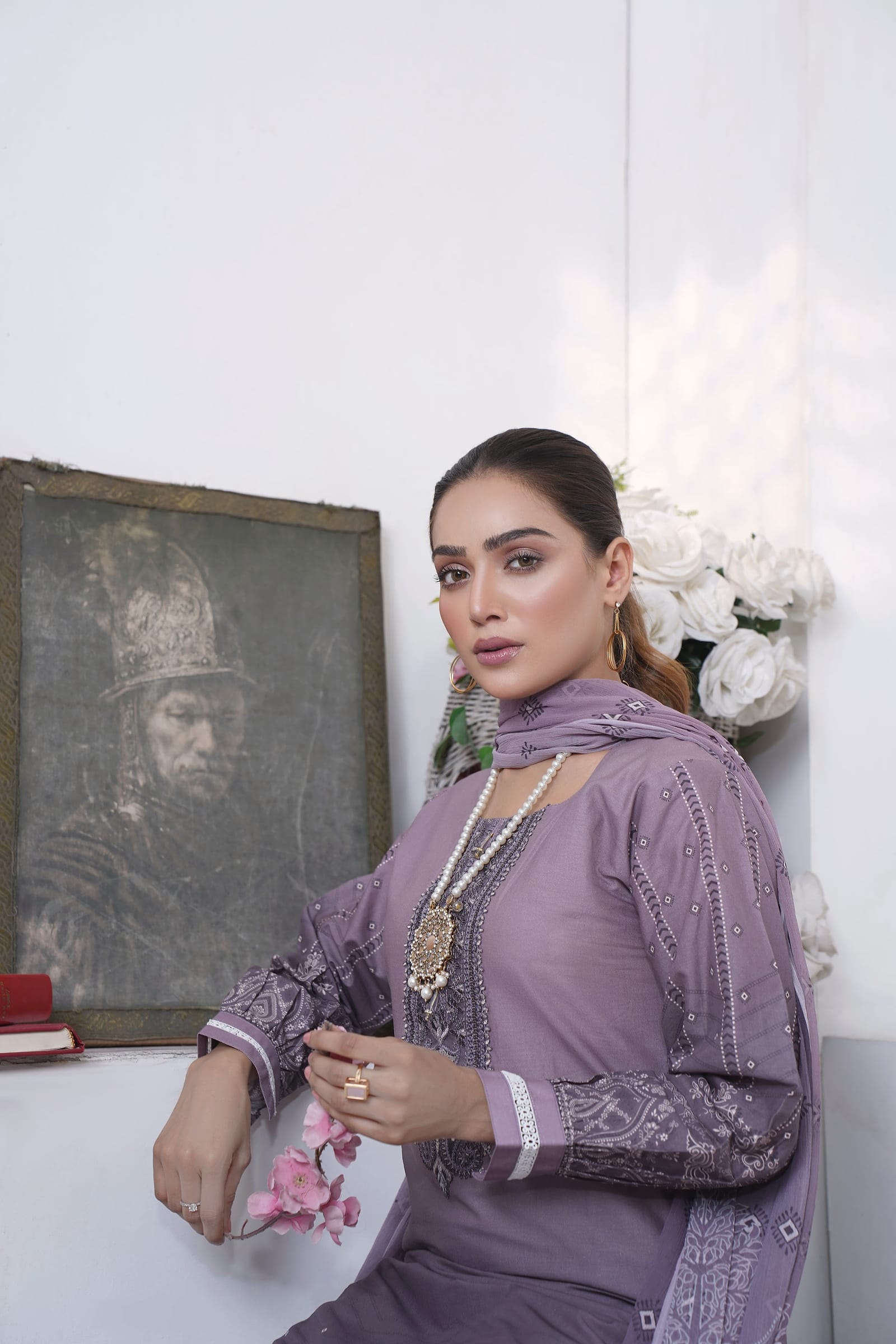 A woman is close, looking at the camera, wearing a dusty lilac kurta set with a tonal print.