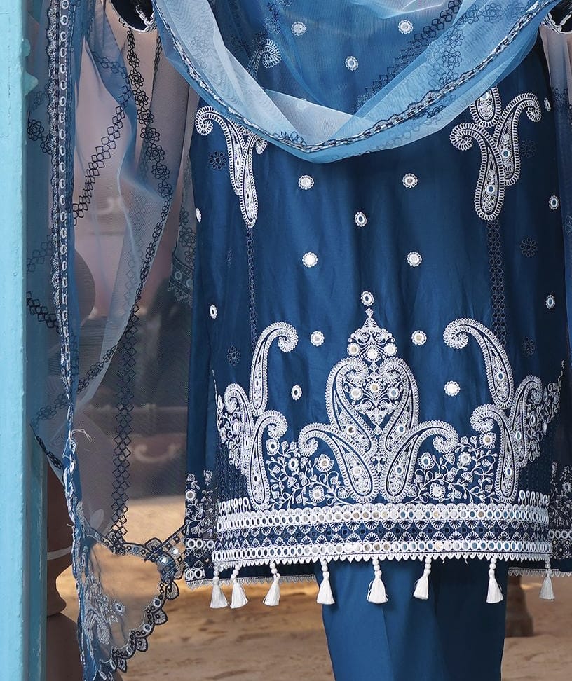 A close detail of a peacock teal-blue kurta set with white paisley embroidery and a pale blue net dupatta: the paisley hem, white embroidery and tassels.